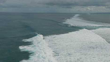 tomada de avión no tripulado de surfistas y patos buceando en las olas en el arrecife de un ojo en mauricio