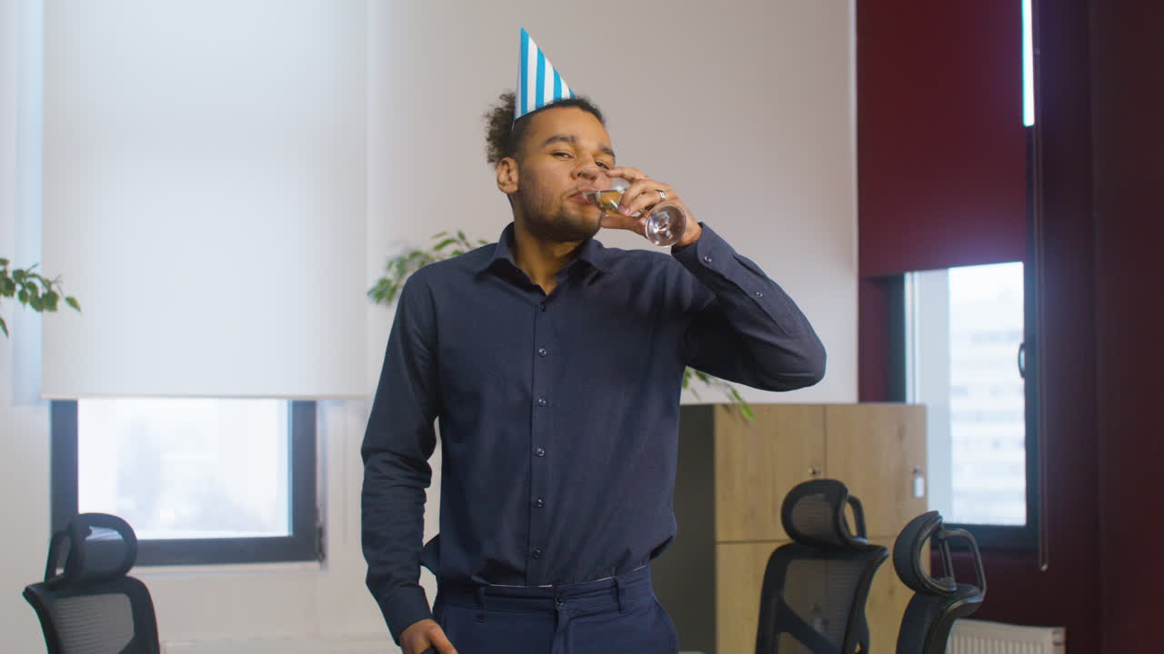 Handsome American Man Drinking Champagne And Looking At The Camera During A Party At The Office 1