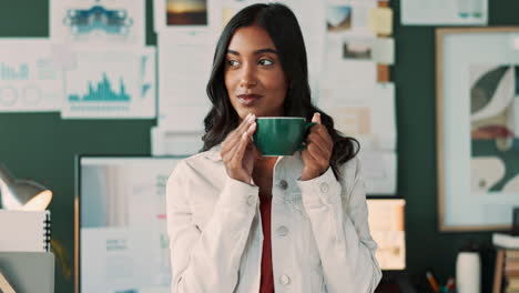 woman drinking coffee at her desk in a modern office