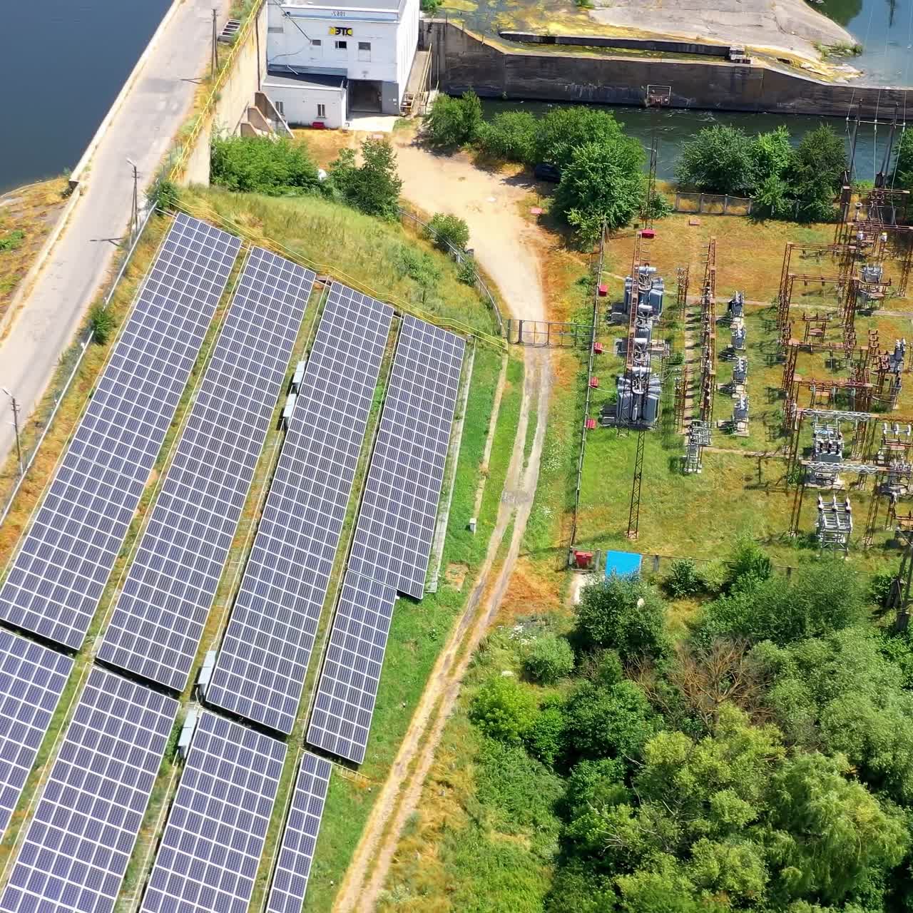 Solar power station near the river at sunlight. Photovoltaic solar cells generate clean energy from the sun on a modern solar farm. Aerial view