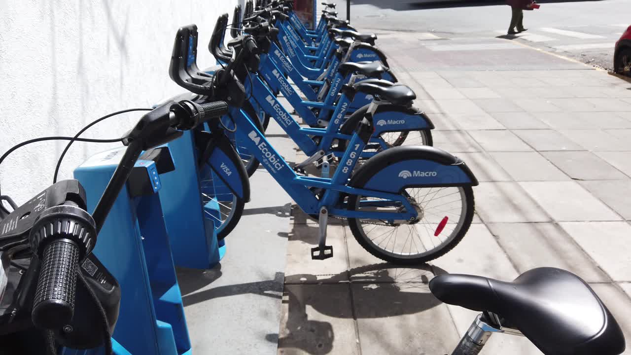 Blue City bicycles service aligned in parking lot of city under daylight