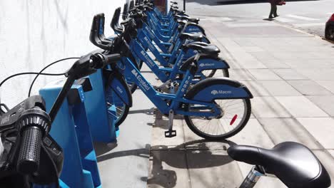 blue city bicycles service aligned in parking lot of city under daylight