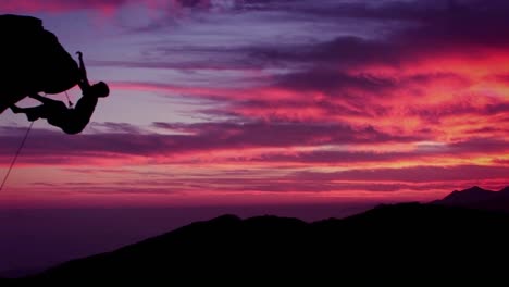 a man climbs a mountain as the sun sets