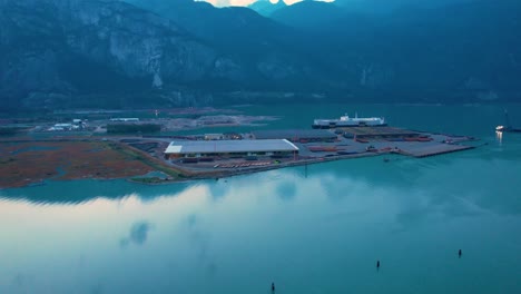 Squamish-Spit-conservation-area-aerial-view-at-sunset-drone-revealing-stunning-mountains-landscape-in-blue-ocean-lake-ocean-water-in-Canada