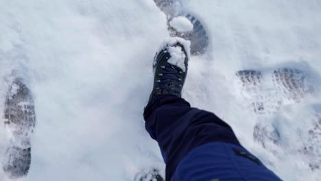 individula walking on a snowy trail, leaving footprints on the way to the slopes of a skiing destination located in engelberg, in brunni, switzerland