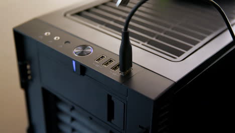 man plugs multiple usb cables into desktop computer