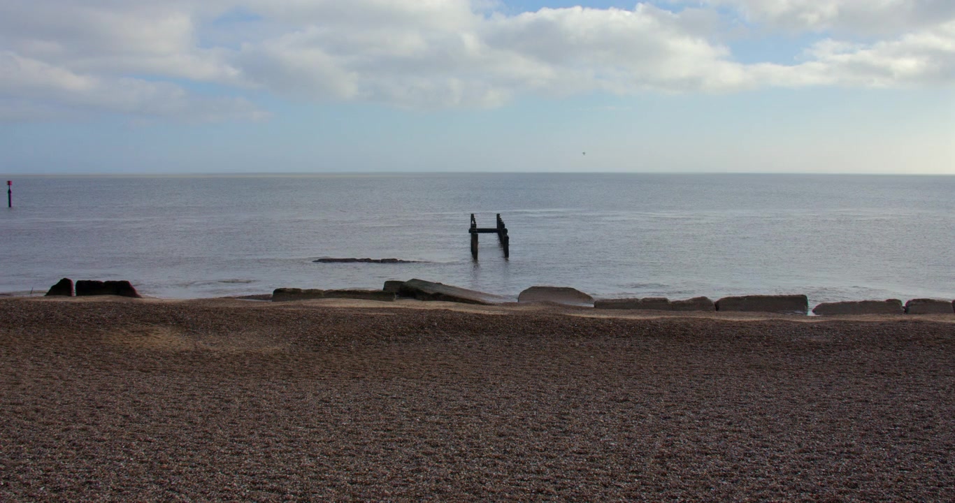 Ampia inquadratura di pennelli frangiflutti rotti in mare sulla spiaggia di Corton, Lowestoft