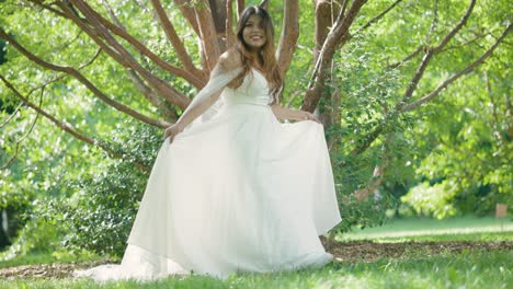 beautiful latina bride with stunning wedding dress reveal walking near green trees