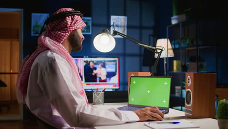 man scrolls on green screen laptop