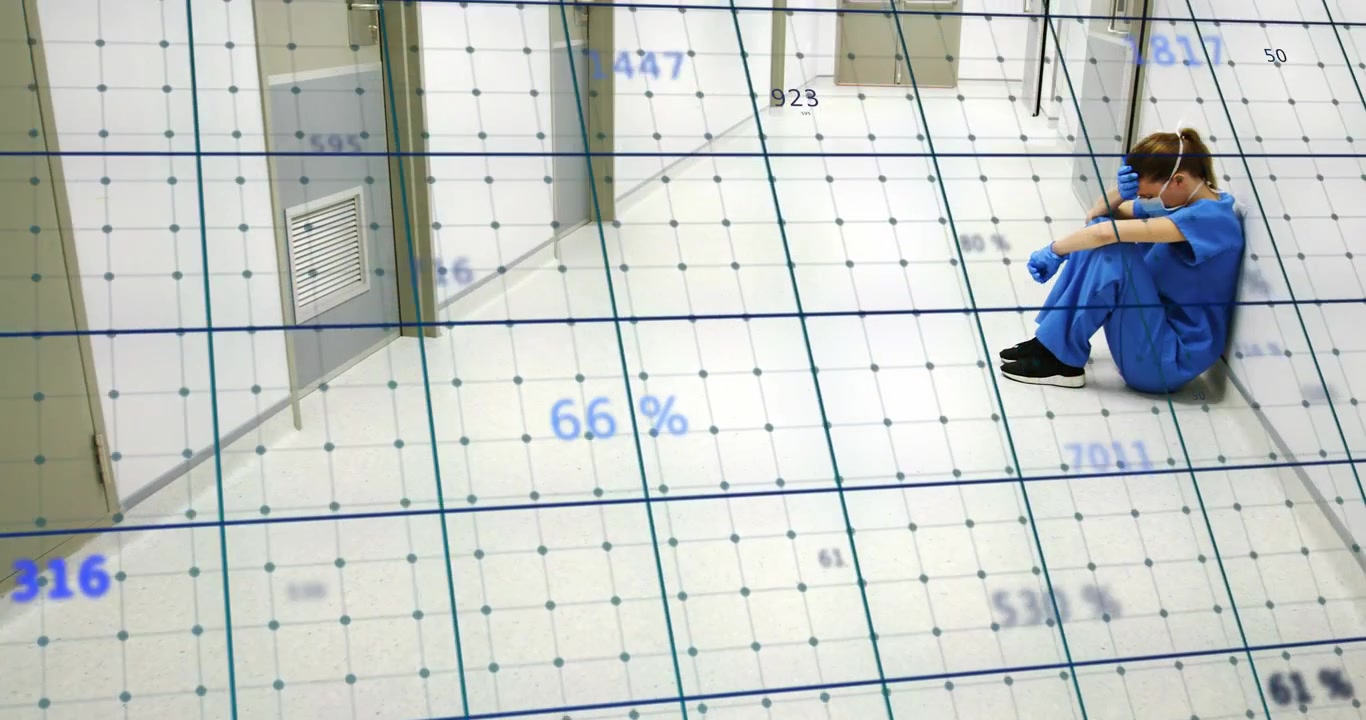 Grid overlay sweeping hospital hallway updating live metrics as health worker sitting hugging knees