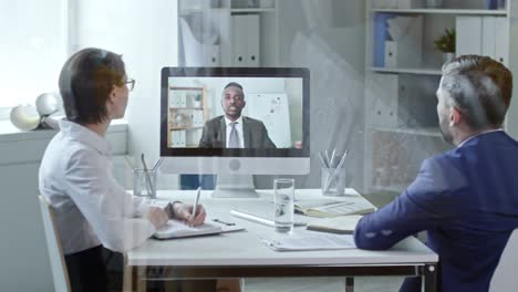 colleagues discussing documents via video call on computer