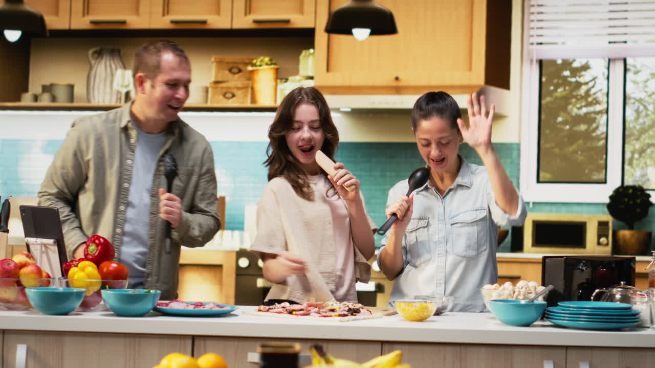 African American family enjoying silly karaoke session for pizza day in kitchen
