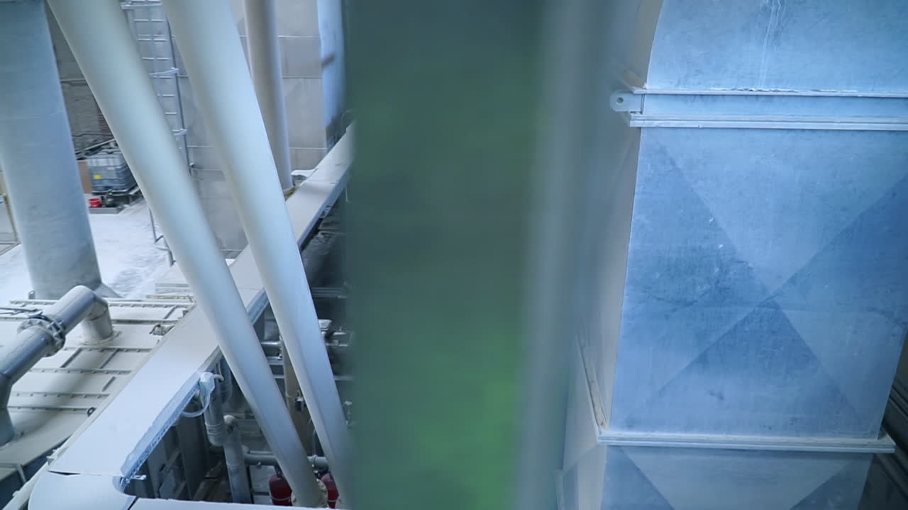 Looking down at the conveyor belt transporting white clay for future processing. Modern kaolin factory.