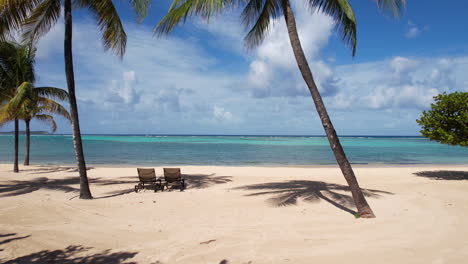 Volando-Entre-Palmeras-Sobre-Tumbonas-Y-Resort-De-Playa-De-Arena-Blanca-En-El-Mar-Caribe,-Disparo-De-Drones