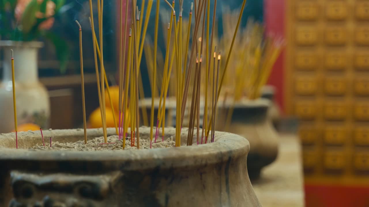 Cinesi che accendono bastoncini d'incenso e pregano all'interno del Tempio Man Mo nel centro di Hong Kong, mostrando rituali e pratiche spirituali tradizionali