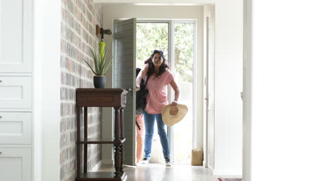 happy diverse senior women opening door and entering home on sunny day, slow motion