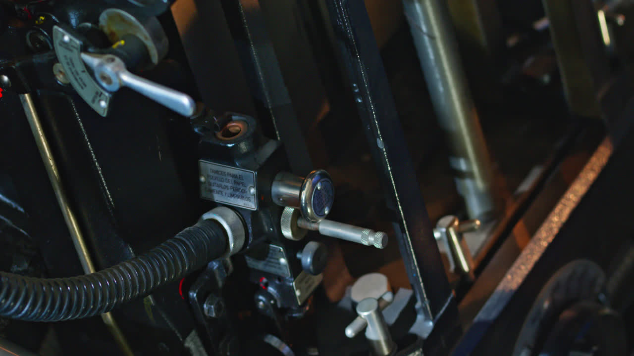 Worker Adjusting Controls on a Vintage Printing Press Machine