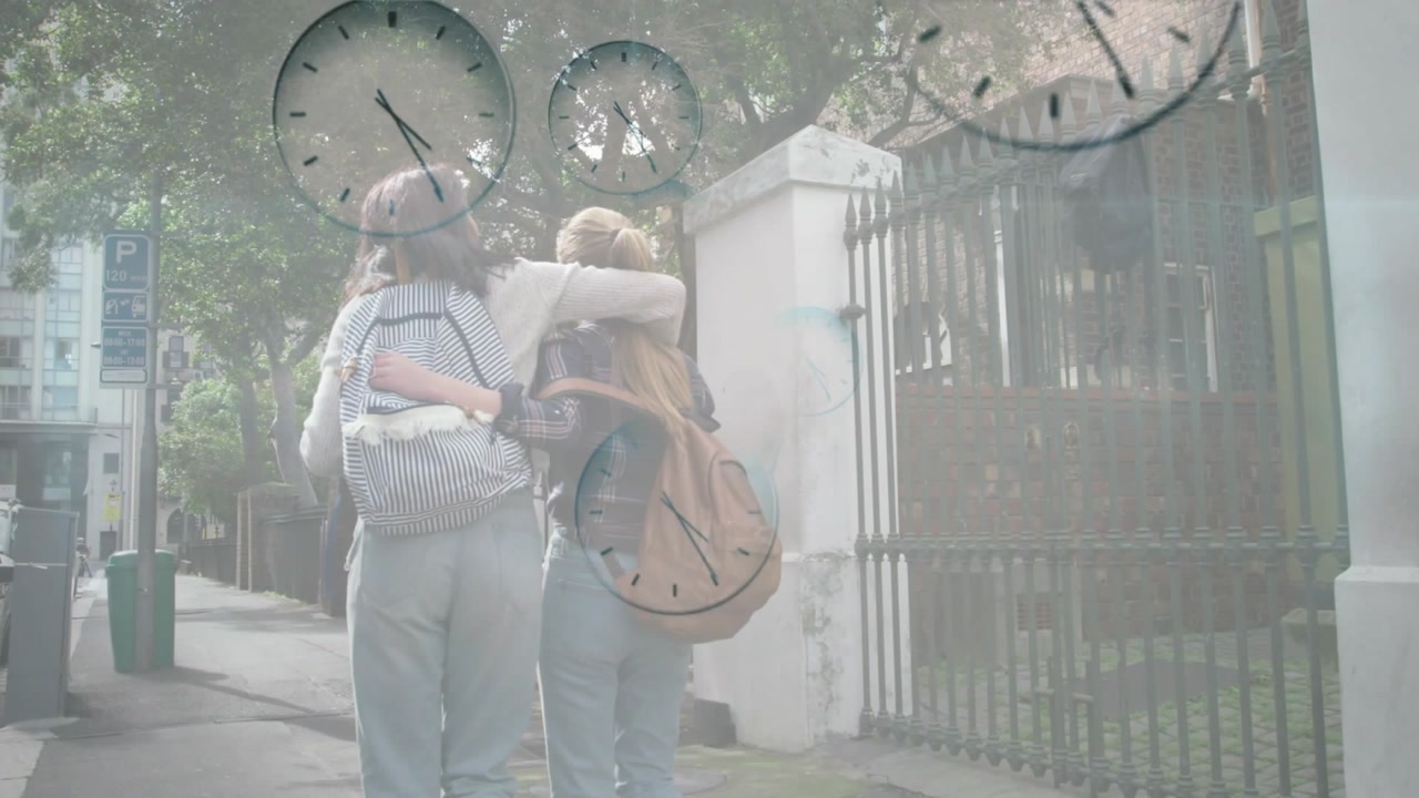Clocks appearing sparking two students walking past iron fence multiplying receding for learning