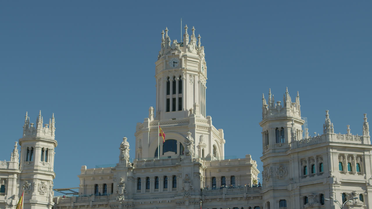 Incredibile inquadratura media della parte superiore del famoso Palazzo di Cibele a Madrid, Spagna, durante il pomeriggio e con il traffico automobilistico che passa.