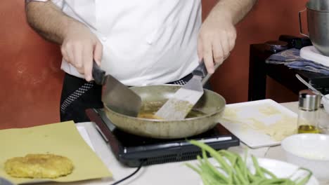 chef cocking cotoletta classic italian meat fried in olive oil pan