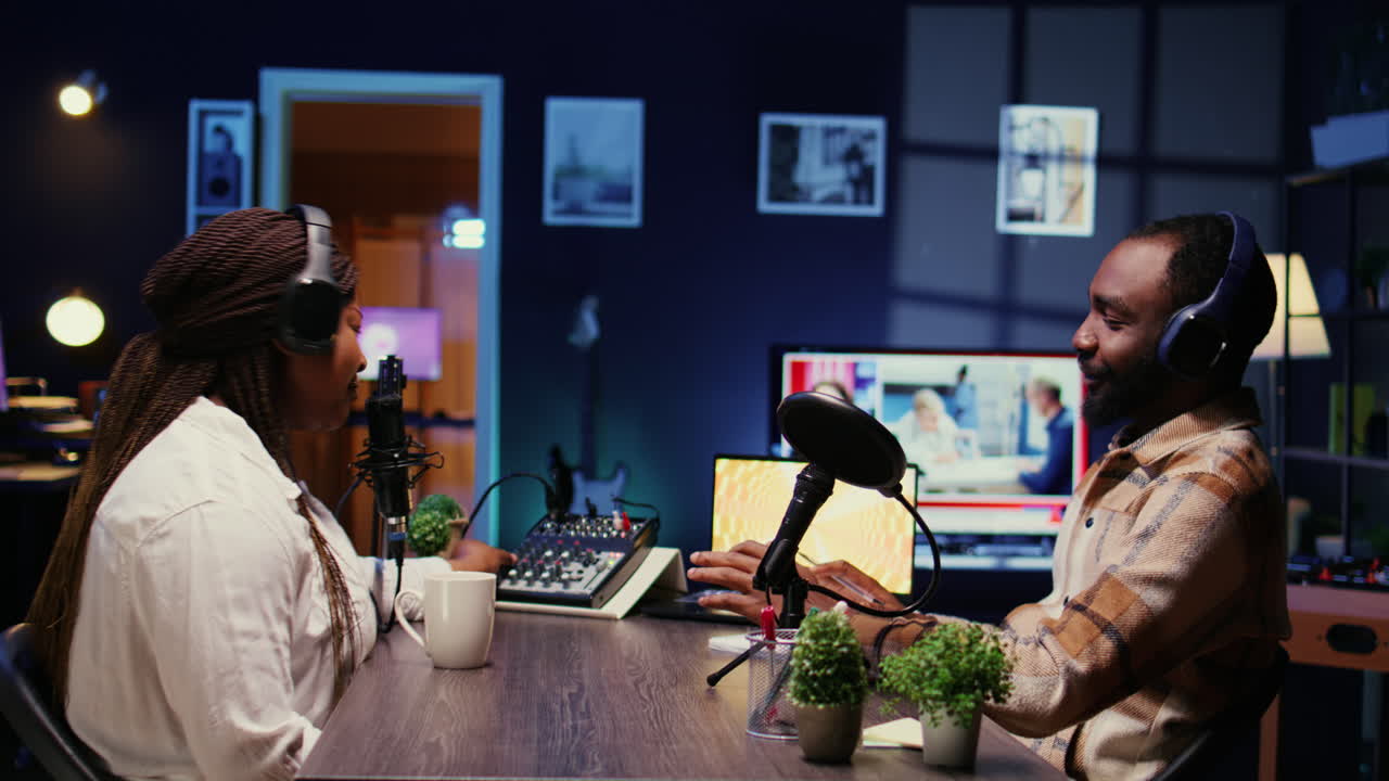 블로거 쇼 호스트와 게스트가 스마트폰을 이용해 스튜디오에서 토론을 녹음합니다.