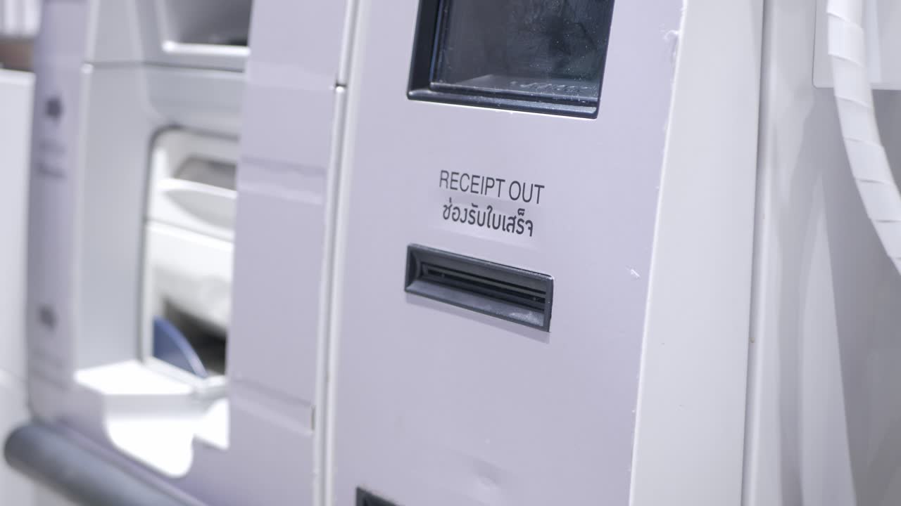 tomando el recibo impreso de los kios de la máquina automática del cajero cuando termine el pago automático en la tienda del supermercado