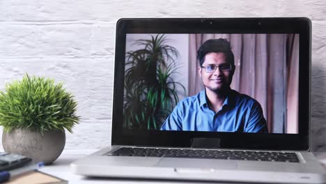 man in video call on laptop