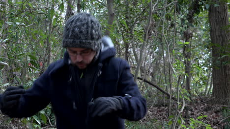 un hombre en un día de invierno en un parque camina y algo en sus manos lo detiene y regresa