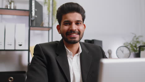 Close-up-businessman-freelancer-at-office-workplace-working-on-laptop-computer-sends-online-messages