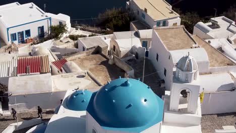 santorini oia thirasia town blue dome church tracking and tilting aerial drone