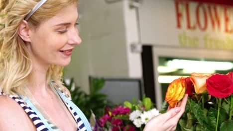 hermosa florista mujer comprobando la rosa
