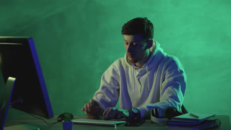 young male and female coworkers working with a computer, wireless headphones and a smartphone on a colorful background