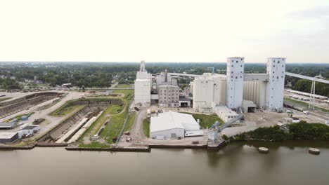 Vista-Panorámica-Aérea-De-Propiedades-Industriales-Y-Comerciales-A-Lo-Largo-De-La-Orilla-De-Un-Río