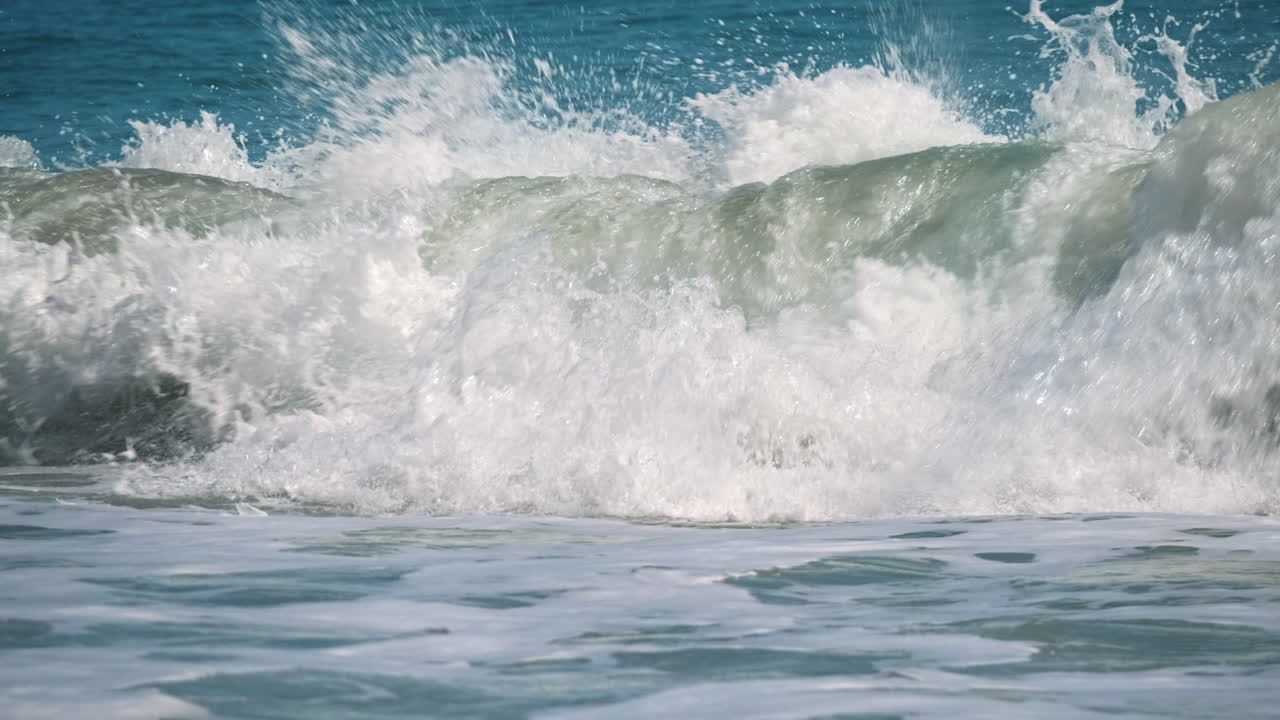 햇빛과 푸른 하늘 동안 거대한 파도를 깨는 슬로우 모션 샷