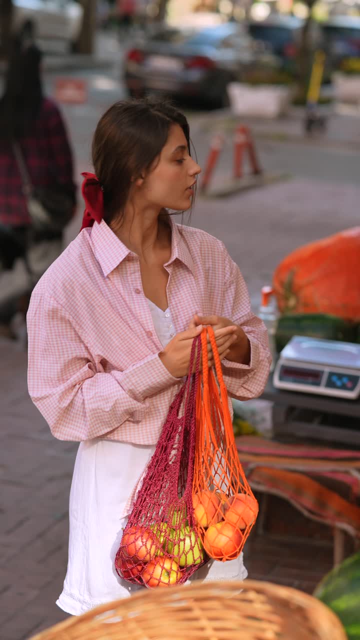 mujer comprando frutas en un mercado callejero