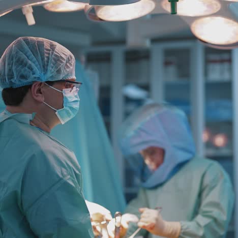 process of trauma surgery operation. group of surgeons wearing protective masks. medical and saving lives concept