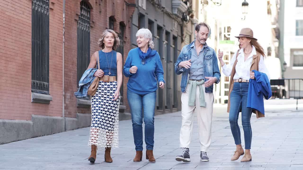 Group of mature people chatting and walking along the street