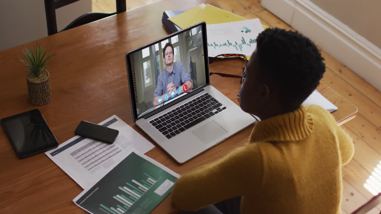 African american woman using laptop on video call with male colleague working from home