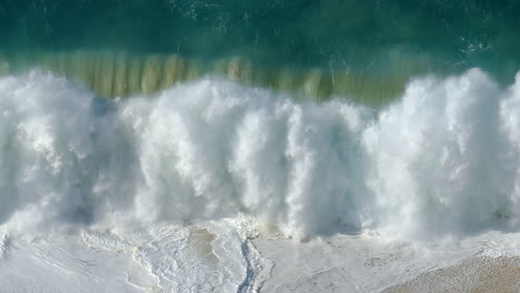 footage of a large wave violently crashing on the shore in cabo san lucas, mexico