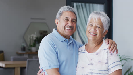 Portrait-of-happy-senior-biracial-couple-embracing