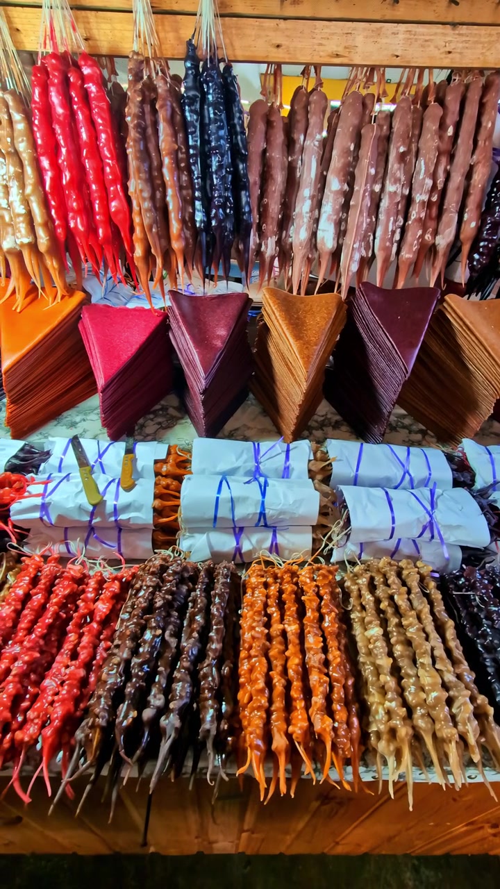 Varietà colorata di dolci tradizionali churchkhela e tklapi in un mercato locale in Georgia.