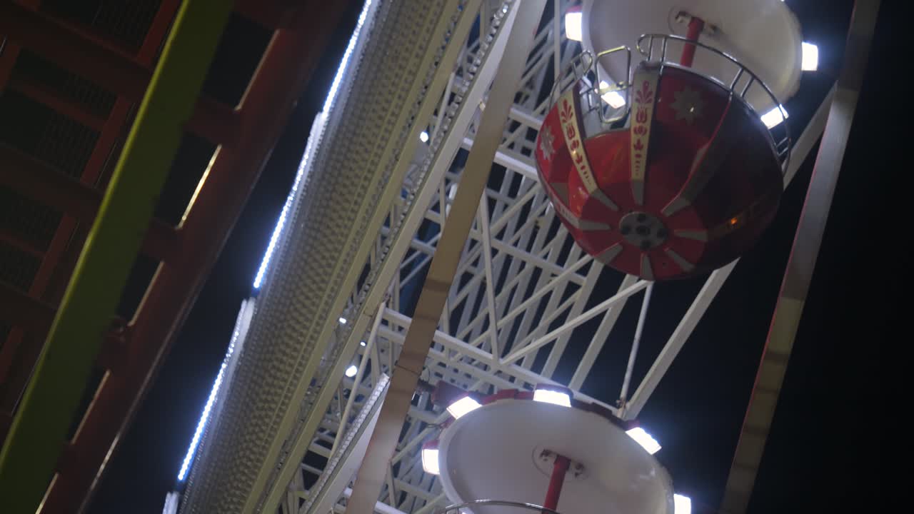 vista cercana de las vainas de la rueda de la fortuna que giran contra un cielo nocturno