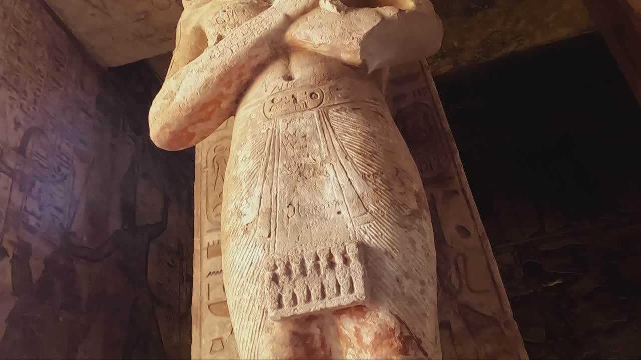 Interior view of the Great Temple at Abu Simbel, featuring colossal statues of Pharaoh Ramses II. The stone carvings and hieroglyphics on the walls.