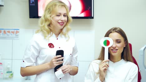 girl checking her eyesight. female ophthalmologist examining patient's eyes. young woman with one eye closed doing vision test with occluder. vision testing concept.