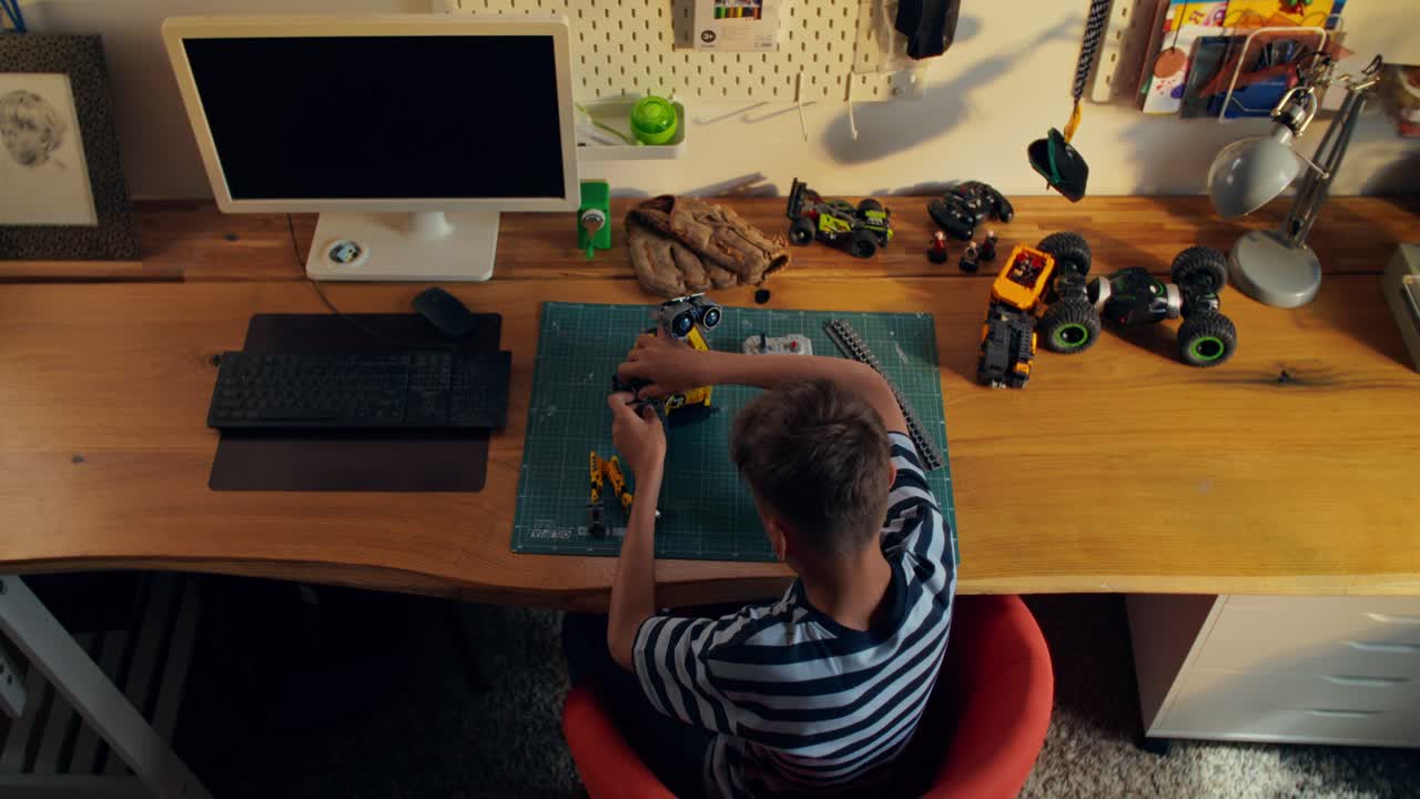Boy Building a Robot Toy at his Desk