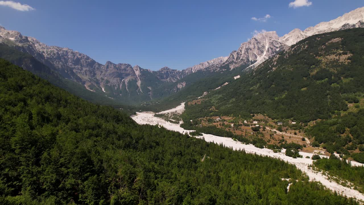 valle rodeado de bosques verdes y montañas de los alpes en verano en valbona, albania