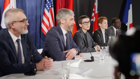group of political leaders talking at international press conference