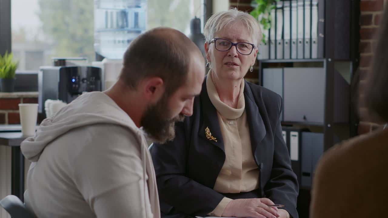 Woman therapist giving advice and guidance to people with mental health issues at aa meeting