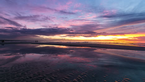 Lapso-De-Tiempo-De-Una-Hermosa-Puesta-De-Sol-Llena-De-Nubes-Y-Su-Reflejo-En-Un-Charco-De-Agua-En-Henley-Beach-South