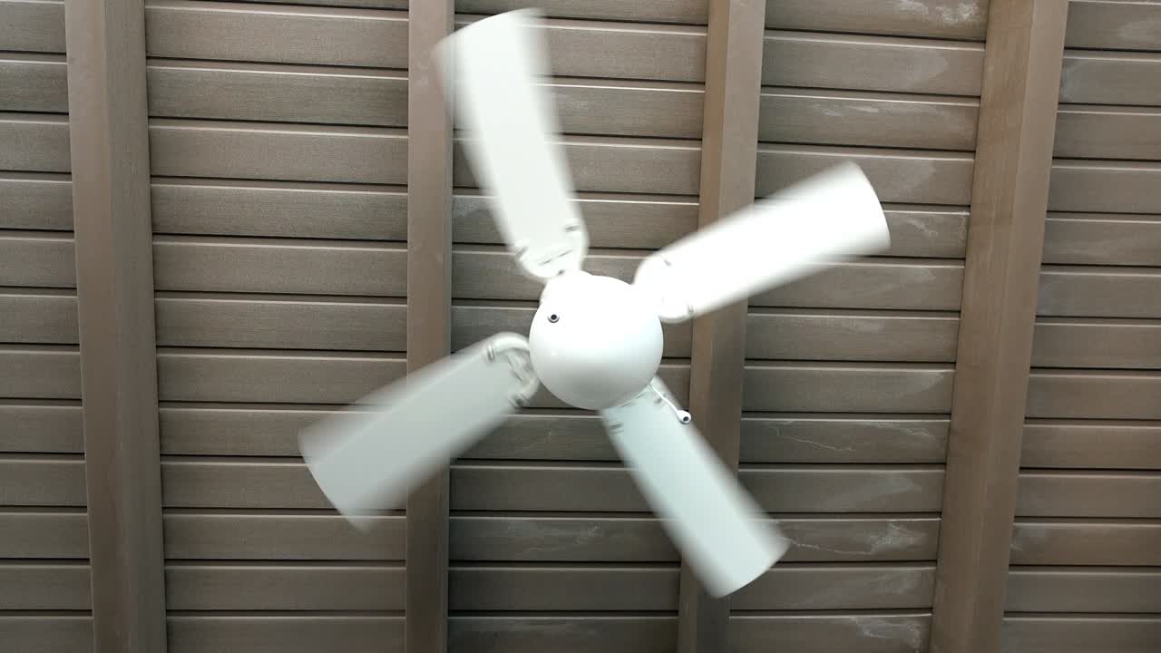 지붕이 있는 카페에서 회전하는 천장 팬.